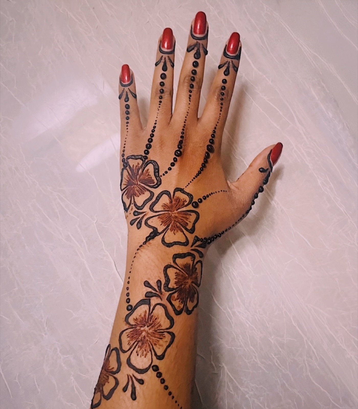 Hibiscus florals tied with bead chains across the back of the hand