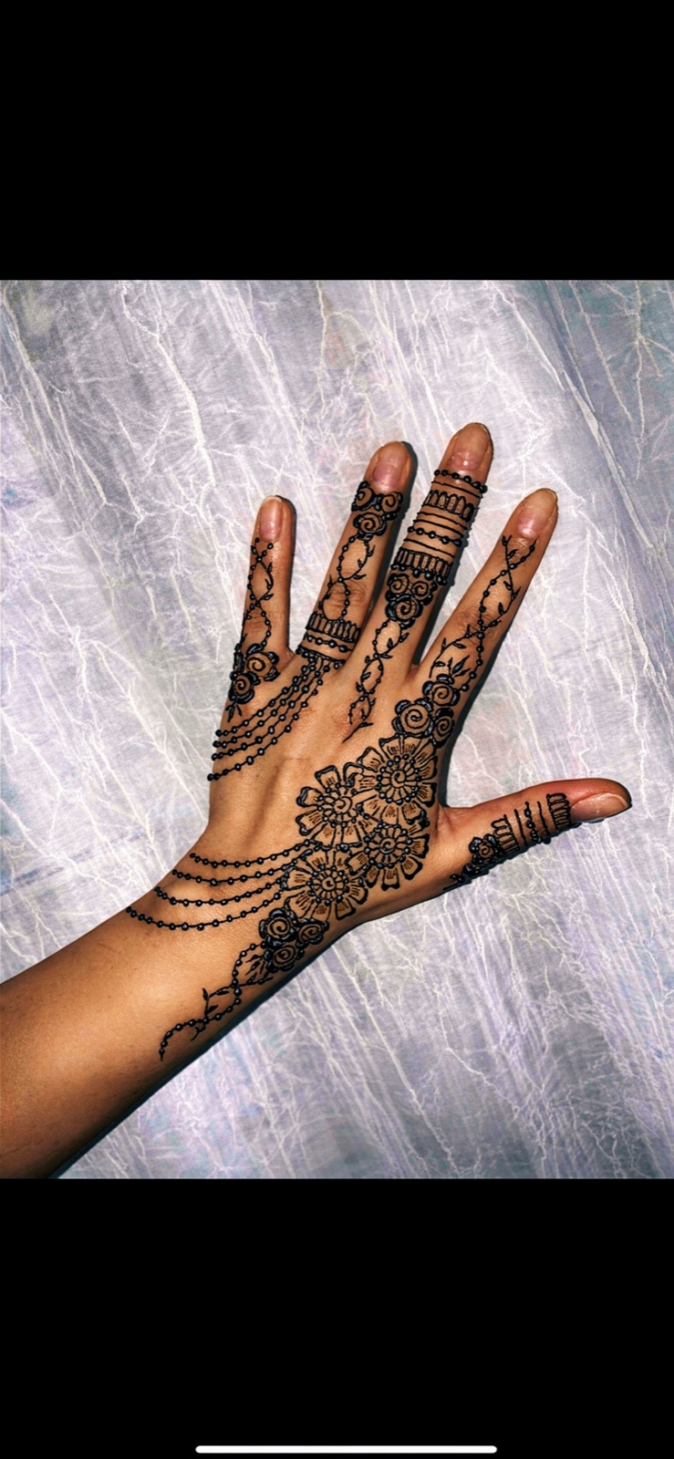 Back-of-hand floral with a bead chain trailing the wrist
